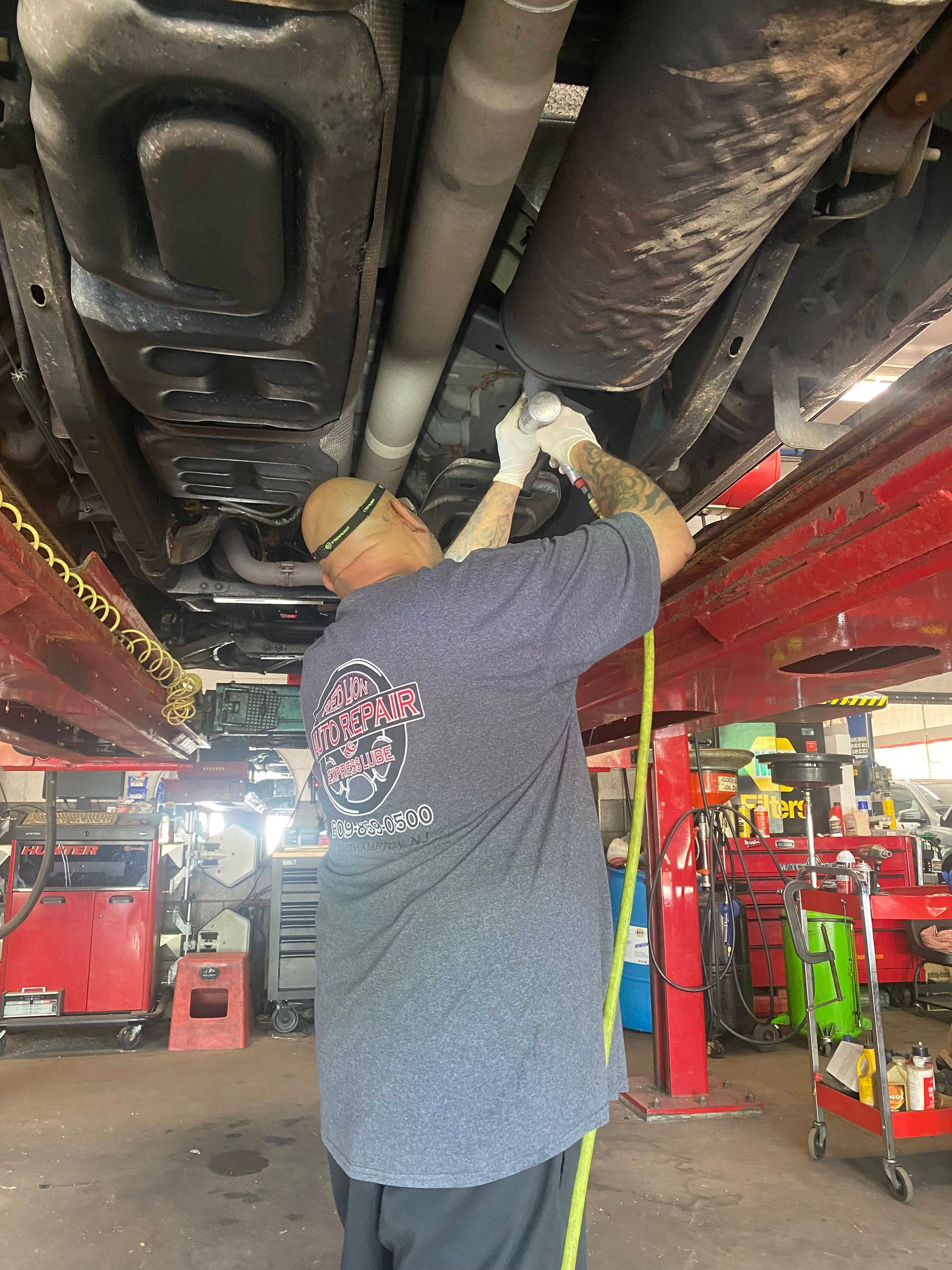 mechanic working under car | Red Lion Express Lube And Auto Repair