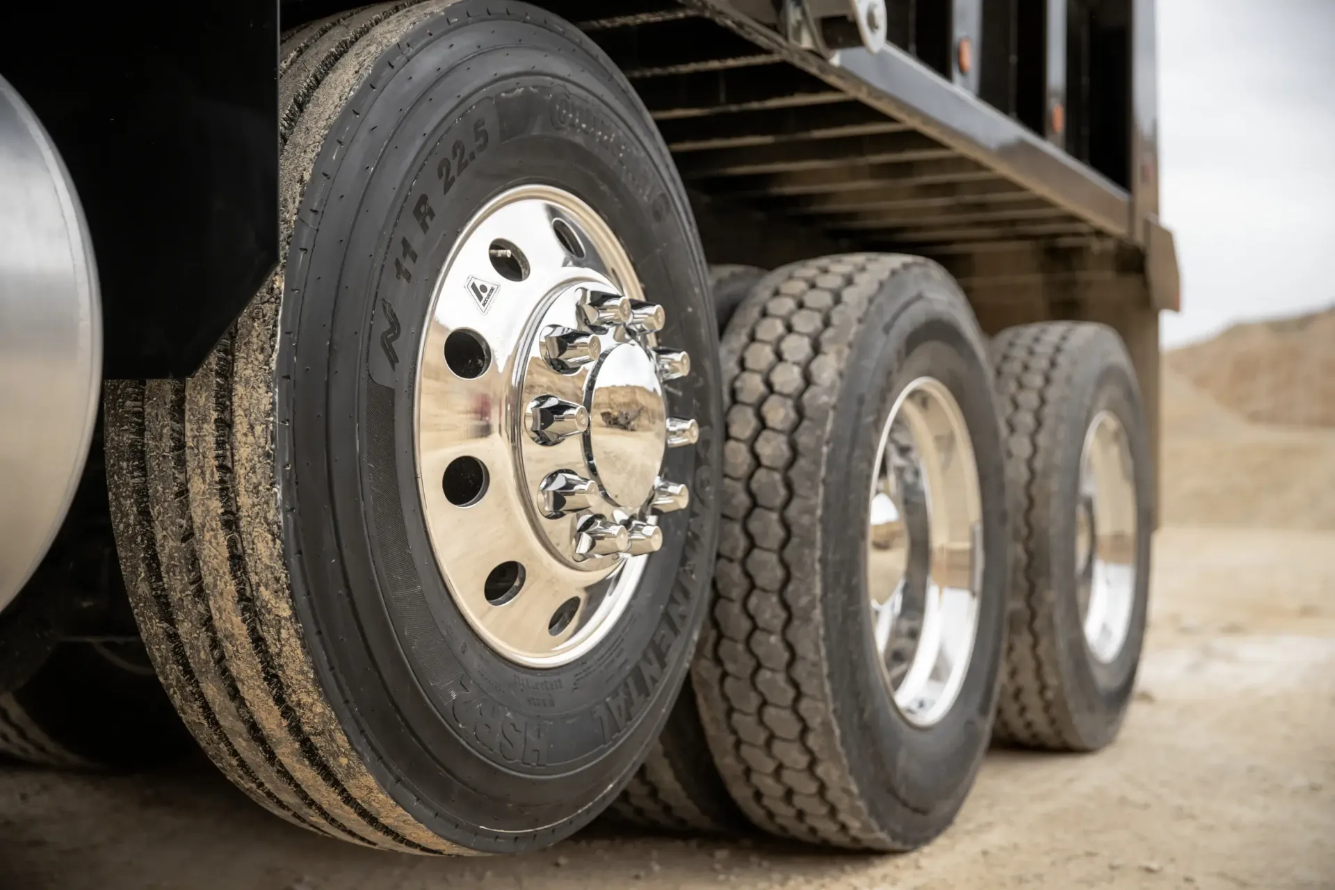 Un hombre conduce un camión y apunta al espejo lateral.