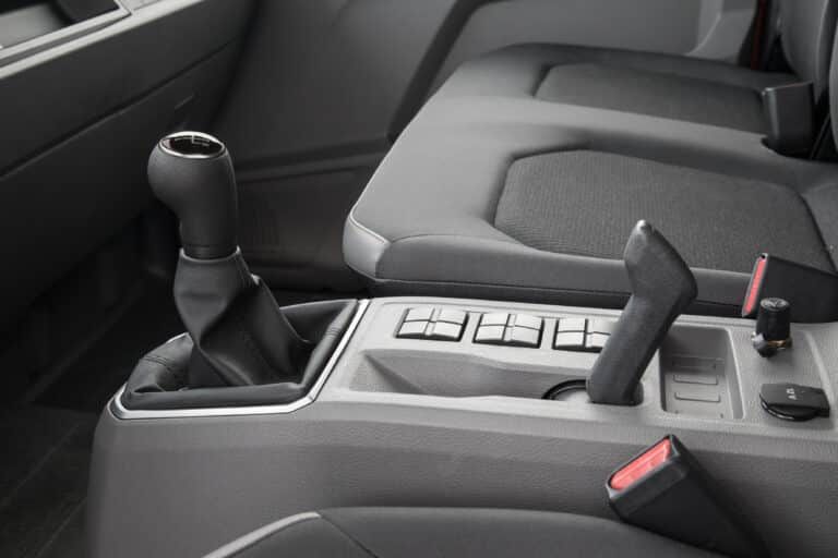 Un primer plano del interior de un camión volkswagen con una palanca de cambios y un cinturón de seguridad.