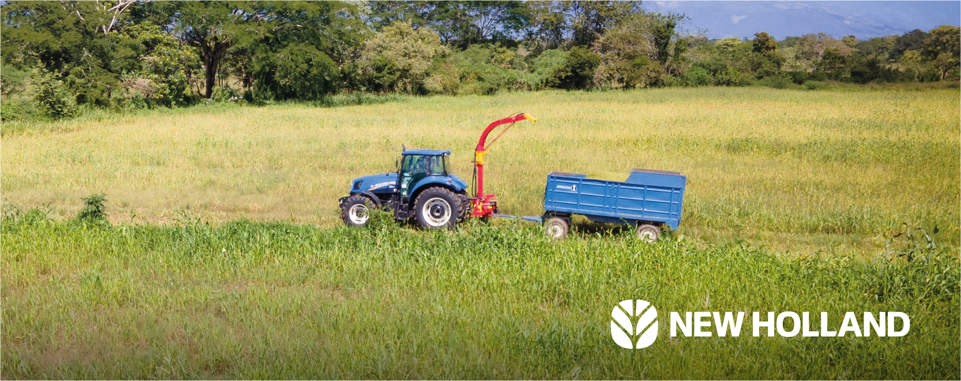 Un tractor New Holland cosechando cultivos en un campo.