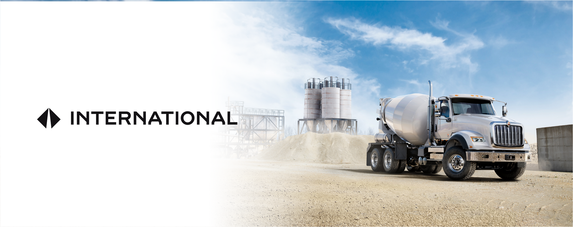 Camión internacional en una obra en construcción, con un cielo nublado al fondo.