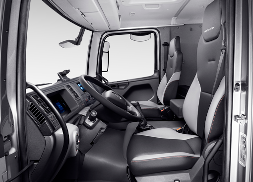 El interior de un camión con volante y asientos.