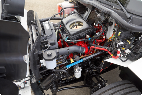 Se muestra el motor de un camión con el capó abierto.