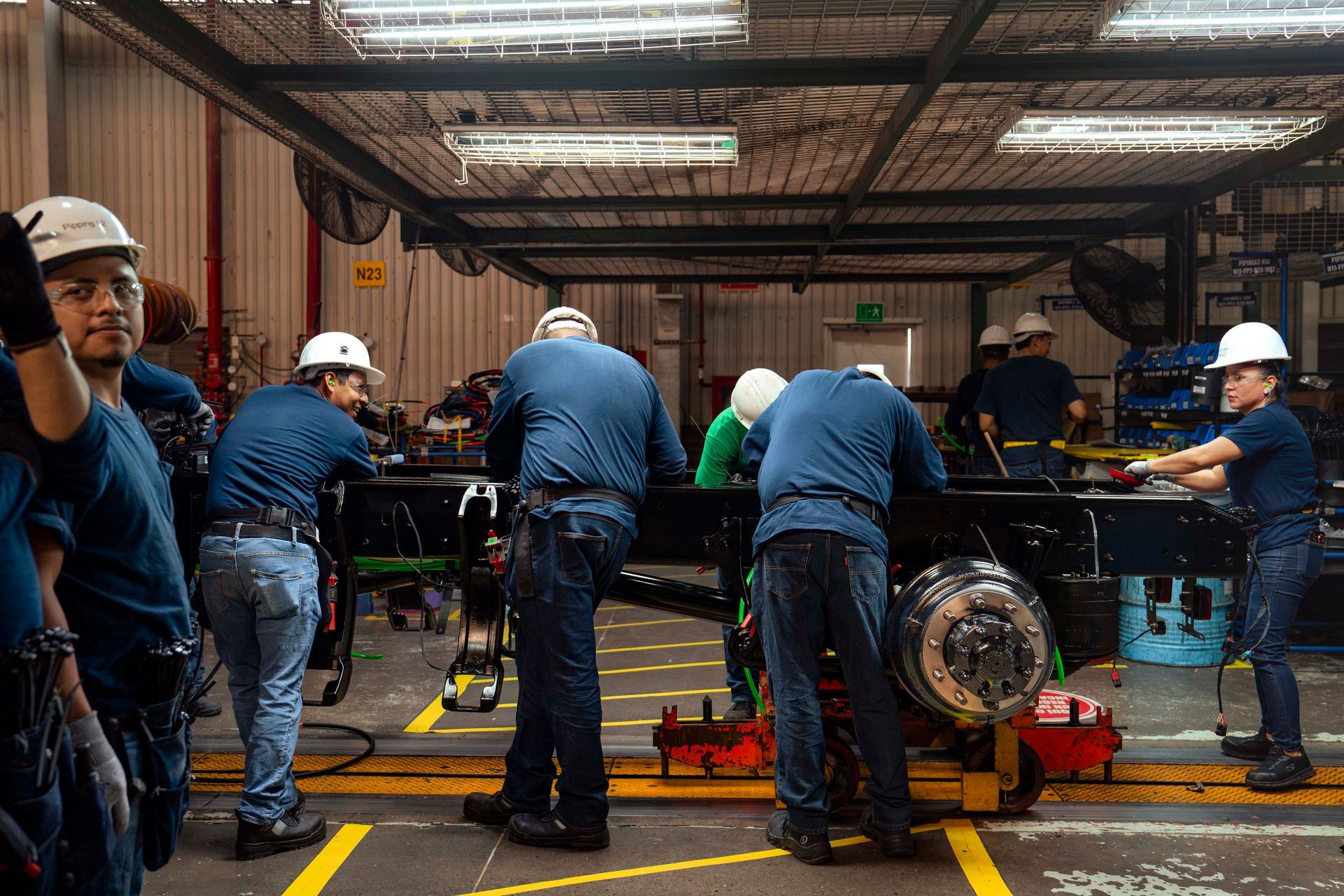 Un grupo de personas está trabajando en un camión en una fábrica.