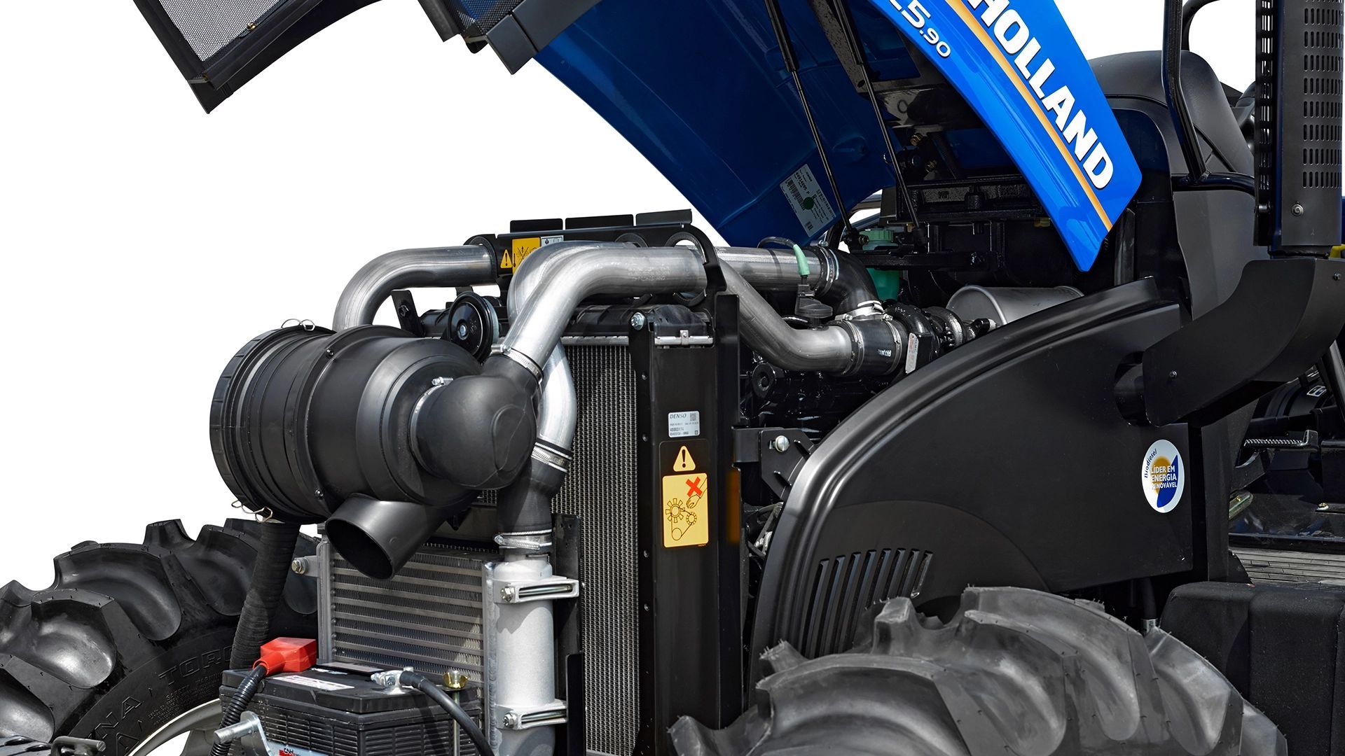 Un tractor New Holland azul y negro está estacionado en un campo.
