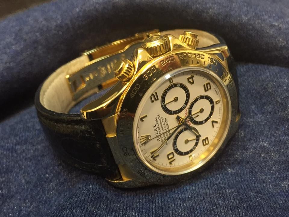 Un orologio Rolex d'oro con cinturino in pelle nera
