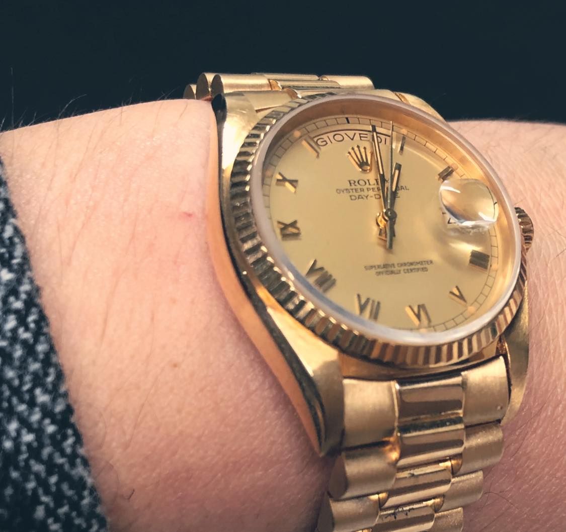 Una persona che indossa un orologio Rolex d'oro al polso