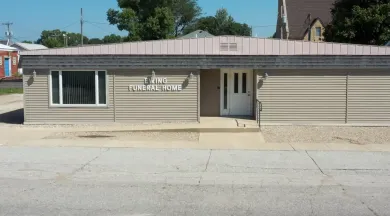 Single-story tan building with a central door, front window, and sign reading “The Chiropractor.”