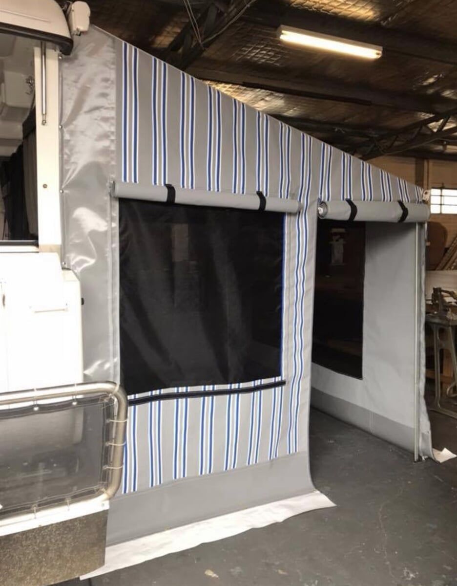 A Striped Tent Is Sitting in A Warehouse Next to A Boat - Quality Canvas Products In Illawarra, NSW