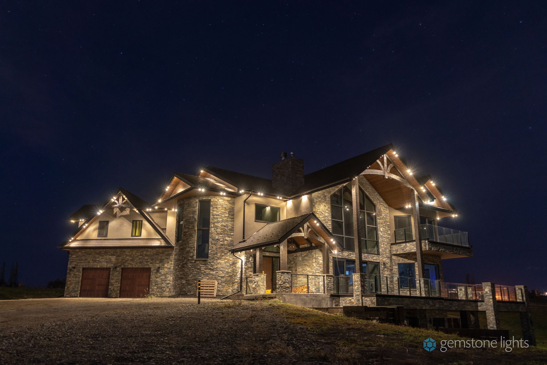 A large house is lit up at night with christmas lights.