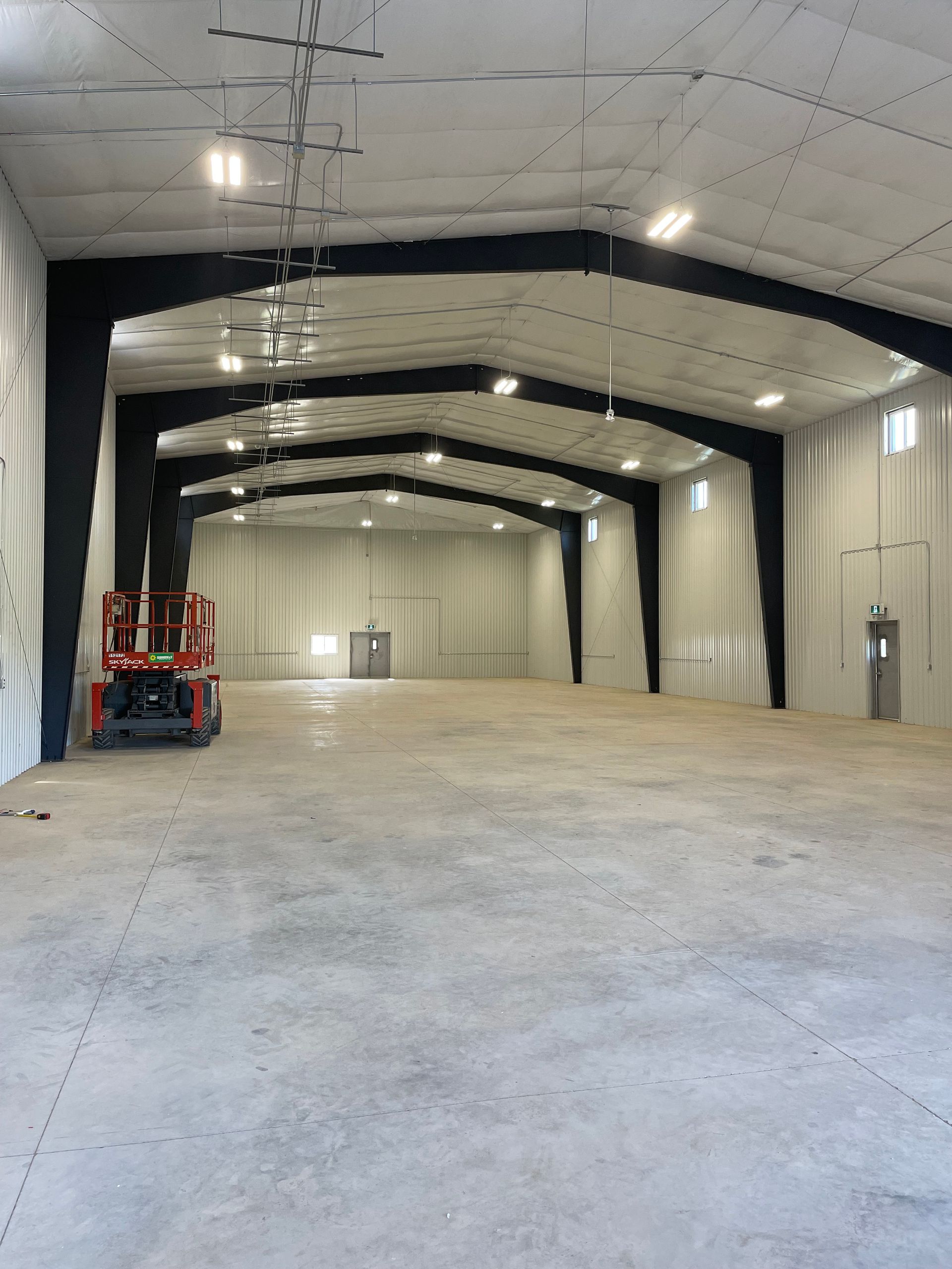 An empty warehouse with a red lift in the middle