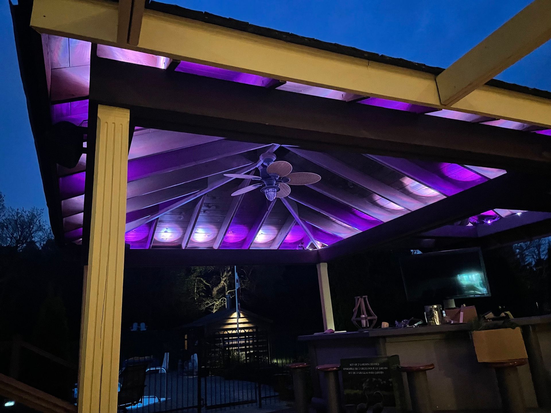 A gazebo with purple lights and a ceiling fan