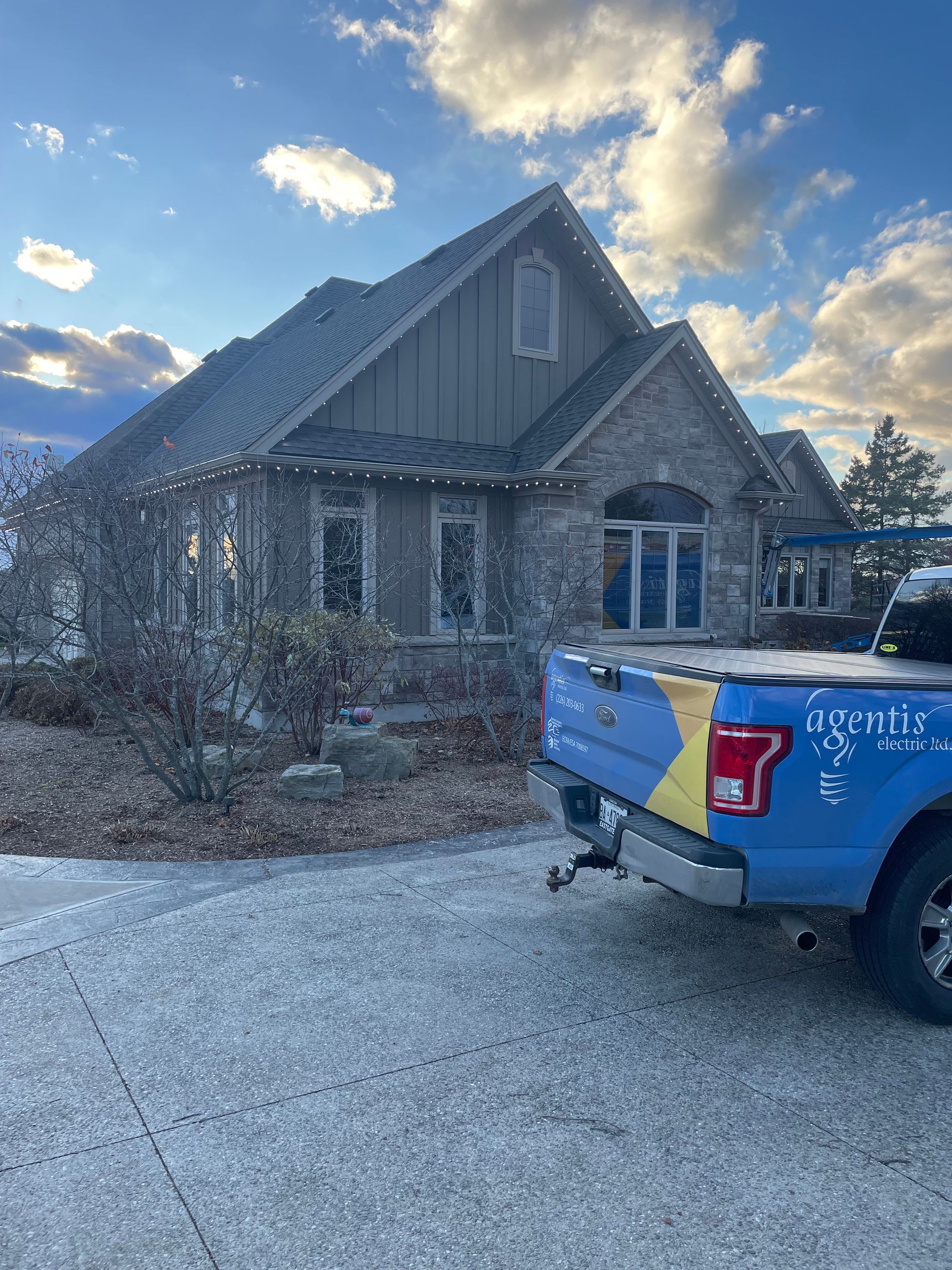 A blue truck is parked in front of a house.
