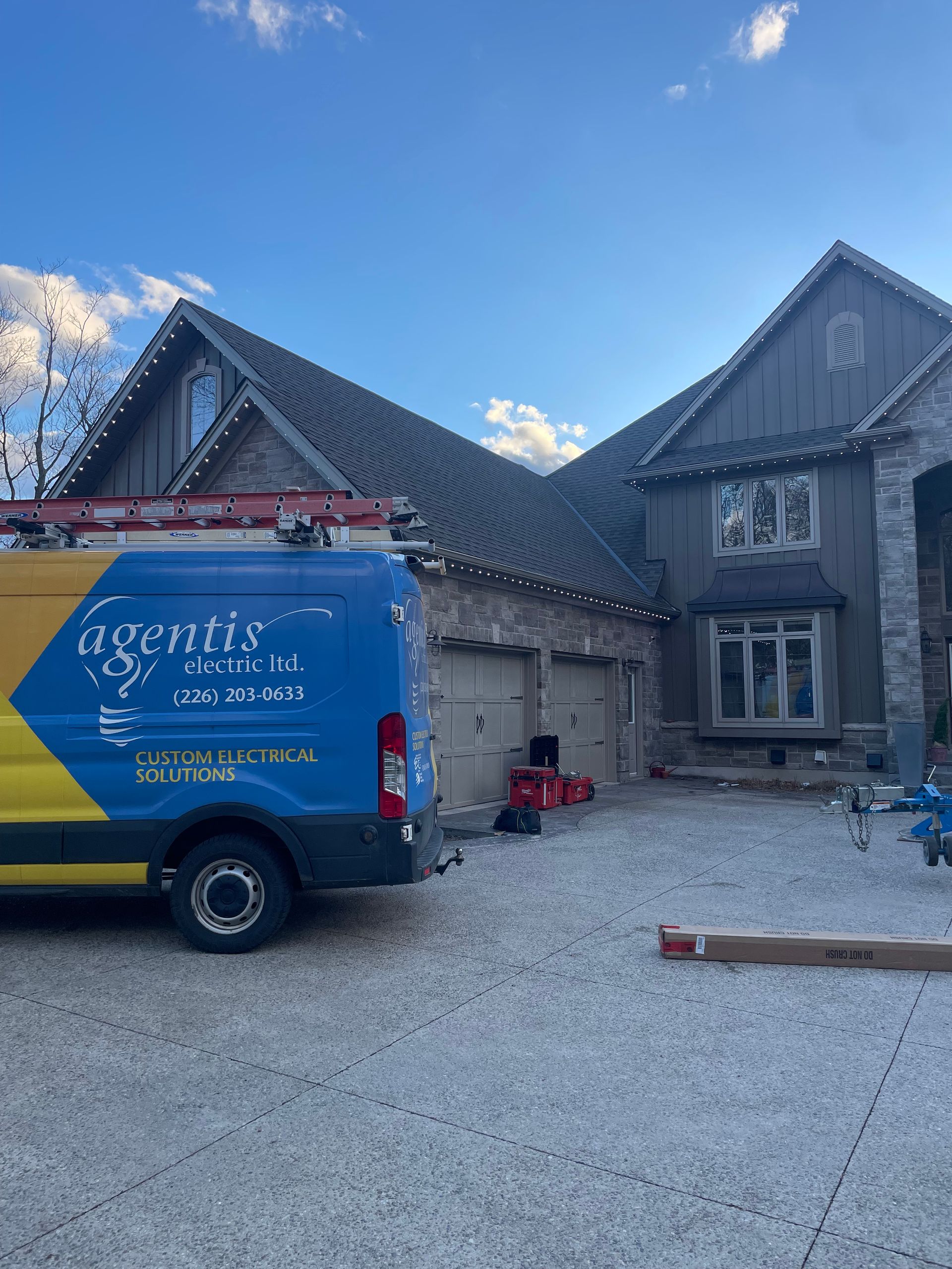 A blue and yellow van is parked in front of a house.