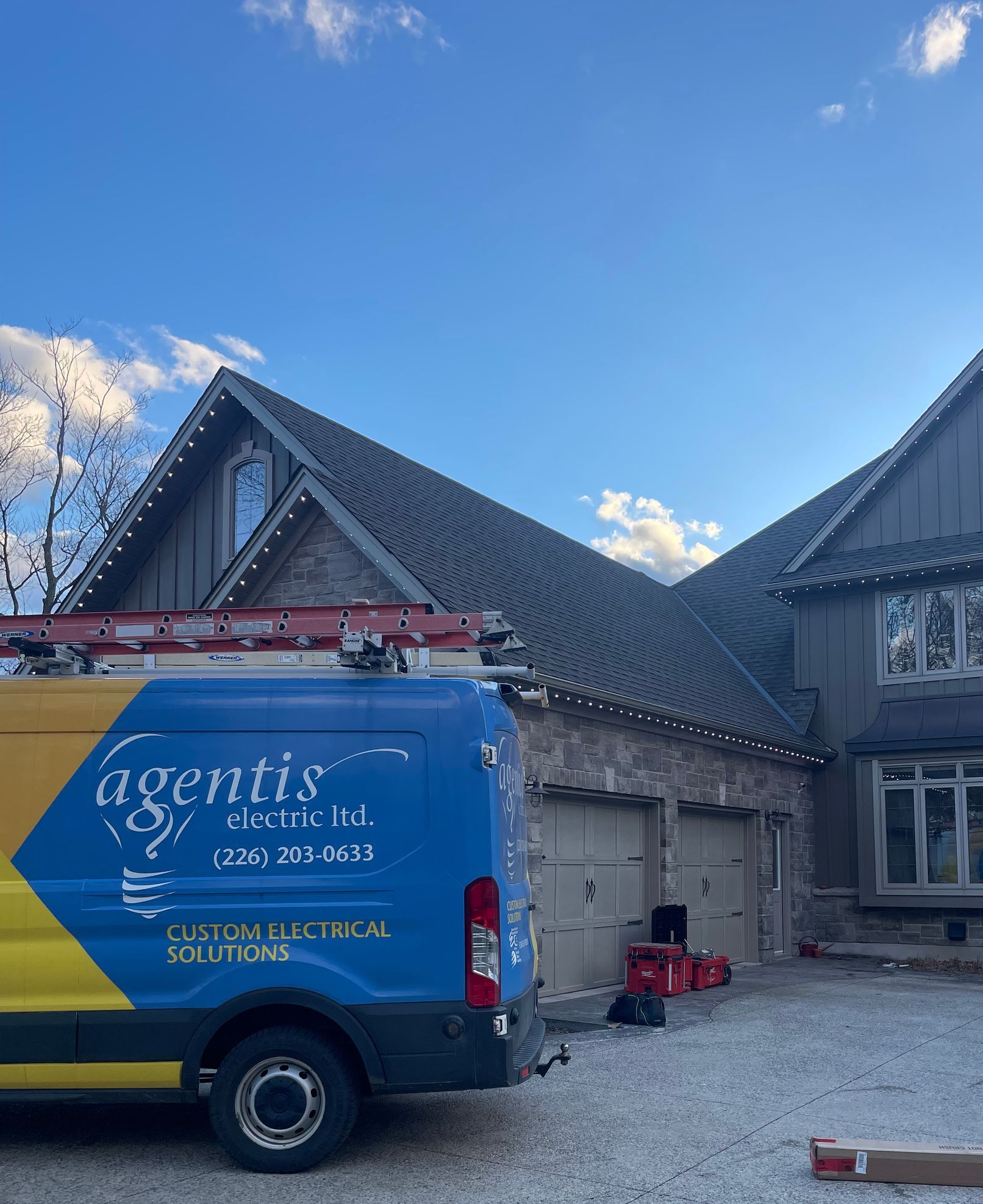 A blue and yellow van is parked in front of a house.