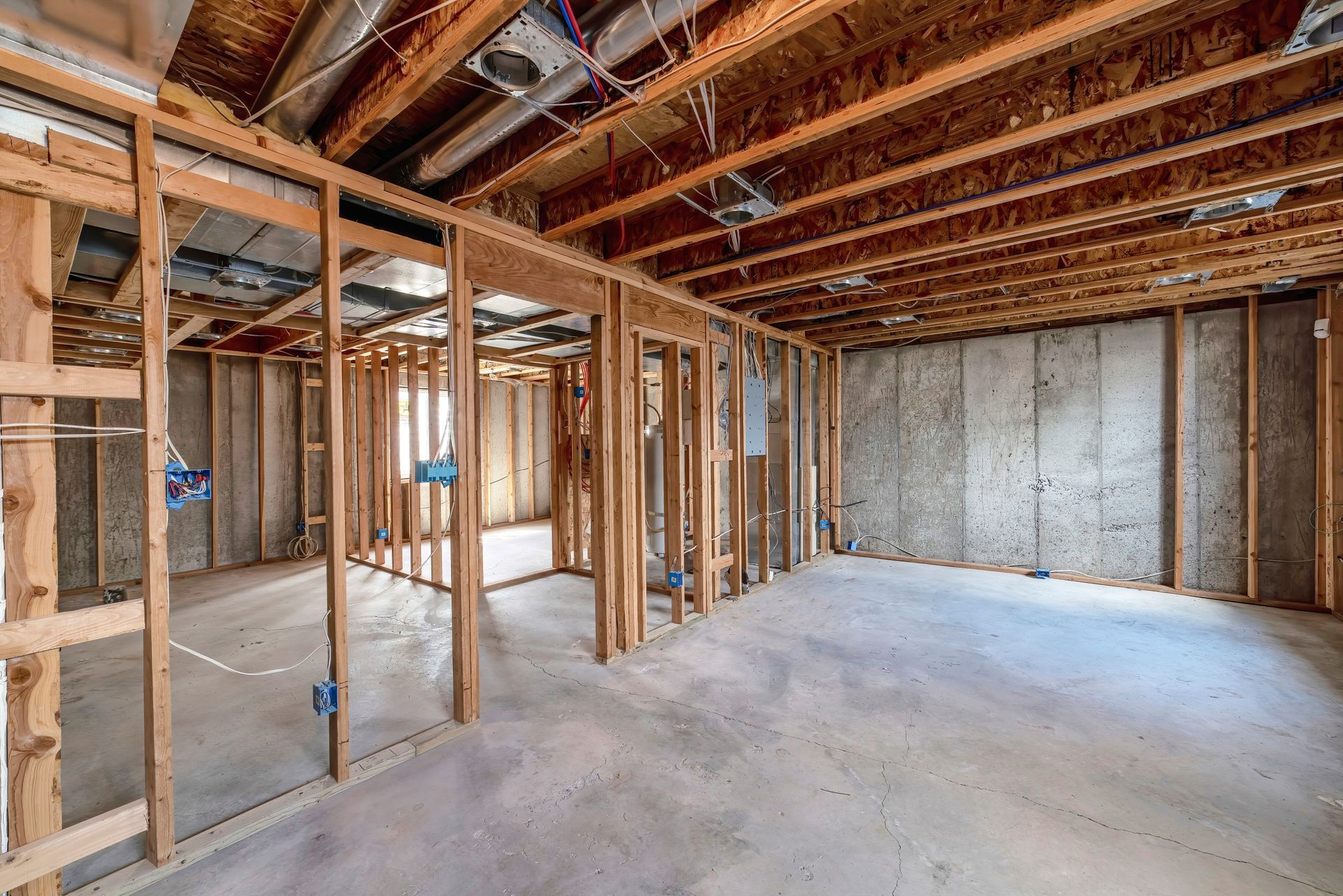 A basement under construction with wooden beams and concrete walls.