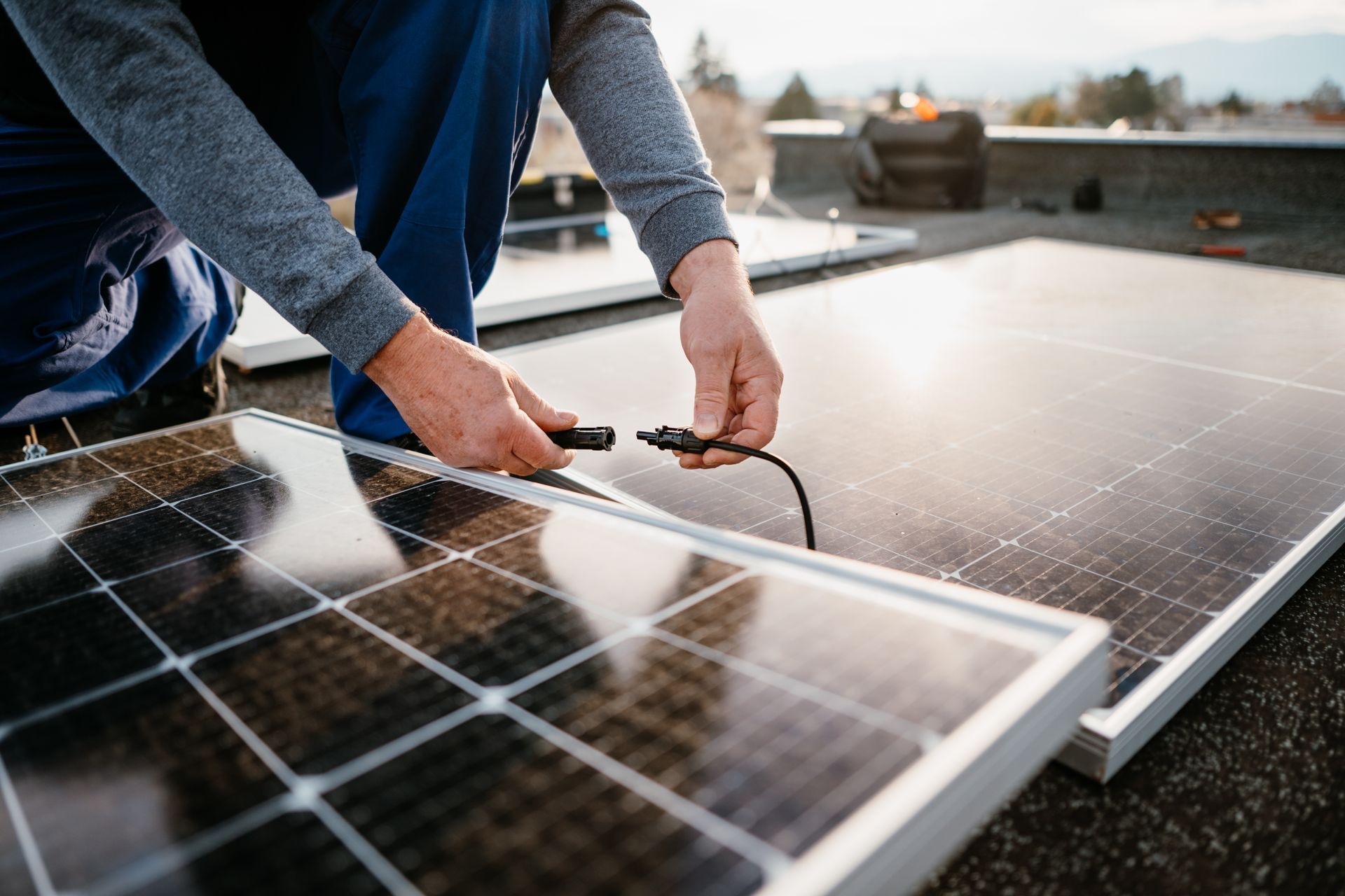 A man is installing solar panels on a roof.