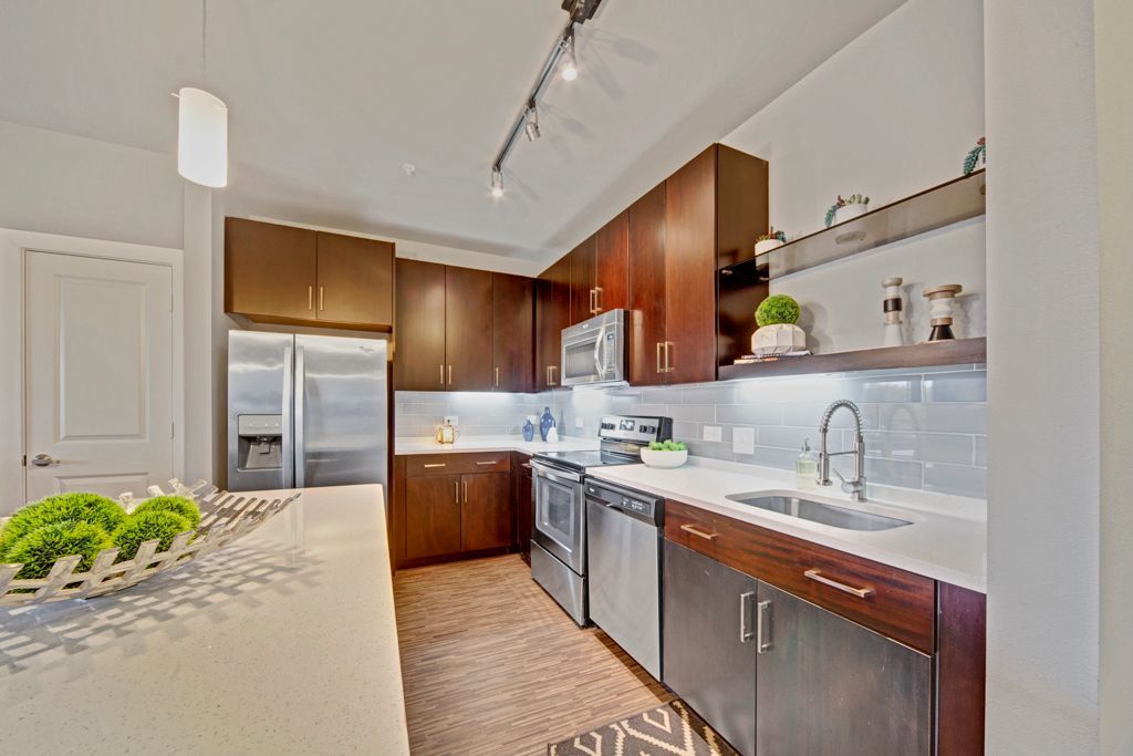 A kitchen with stainless steel appliances and wooden cabinets.