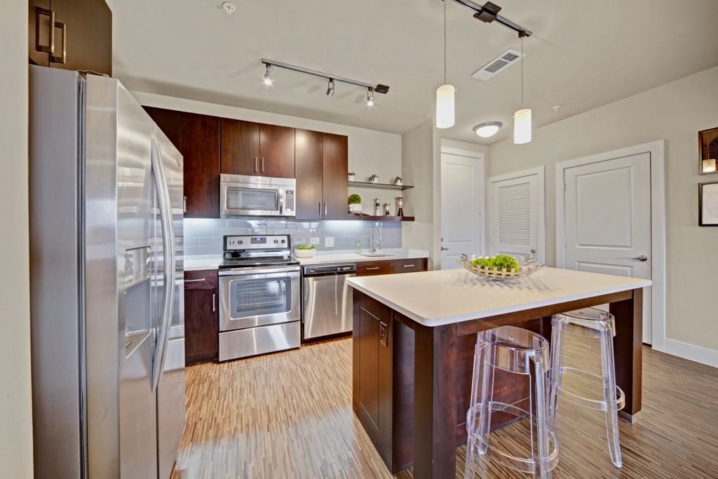 A kitchen with stainless steel appliances and a large island.
