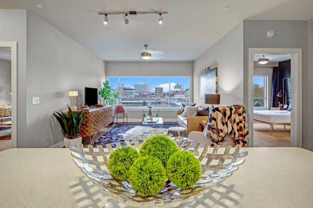 A bowl of green balls is sitting on a table in a living room.