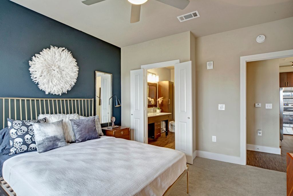 A bedroom with a large bed and a ceiling fan.