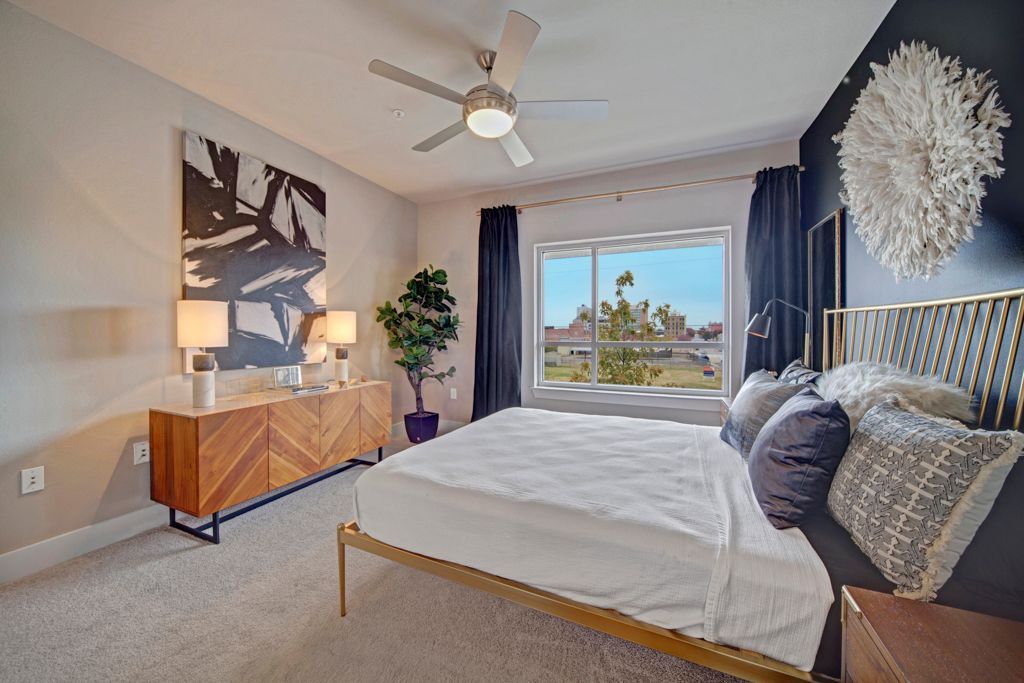 A bedroom with a large bed and a ceiling fan.