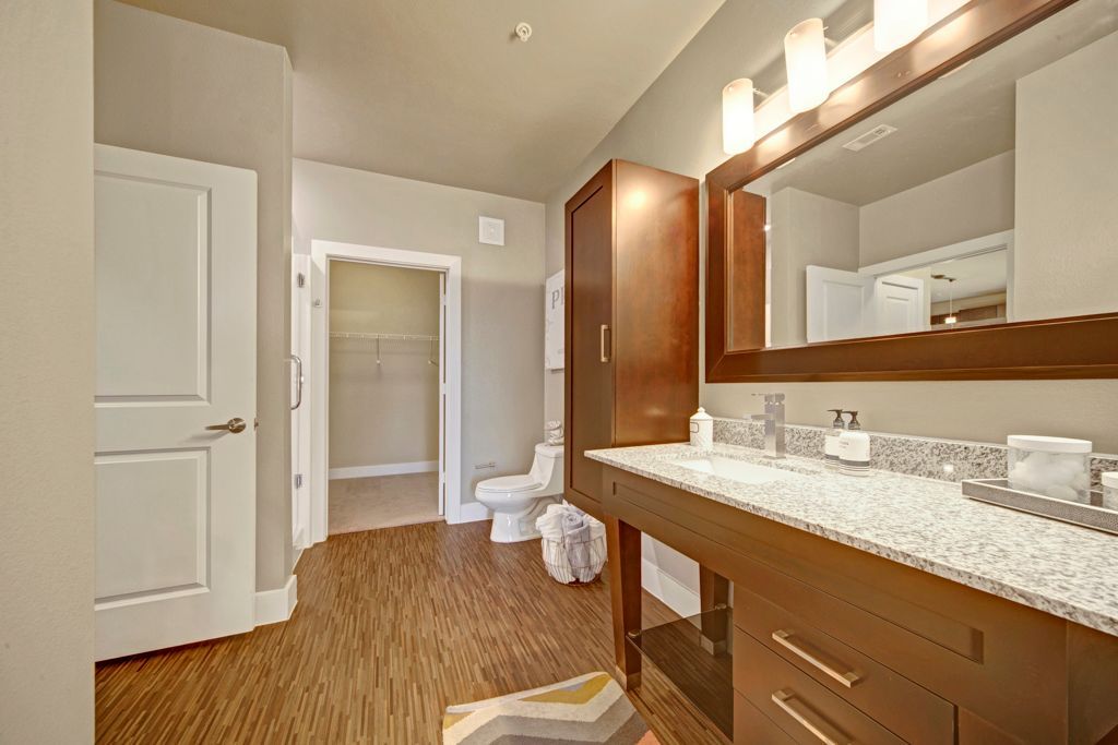 A bathroom with two sinks , a toilet and a mirror.
