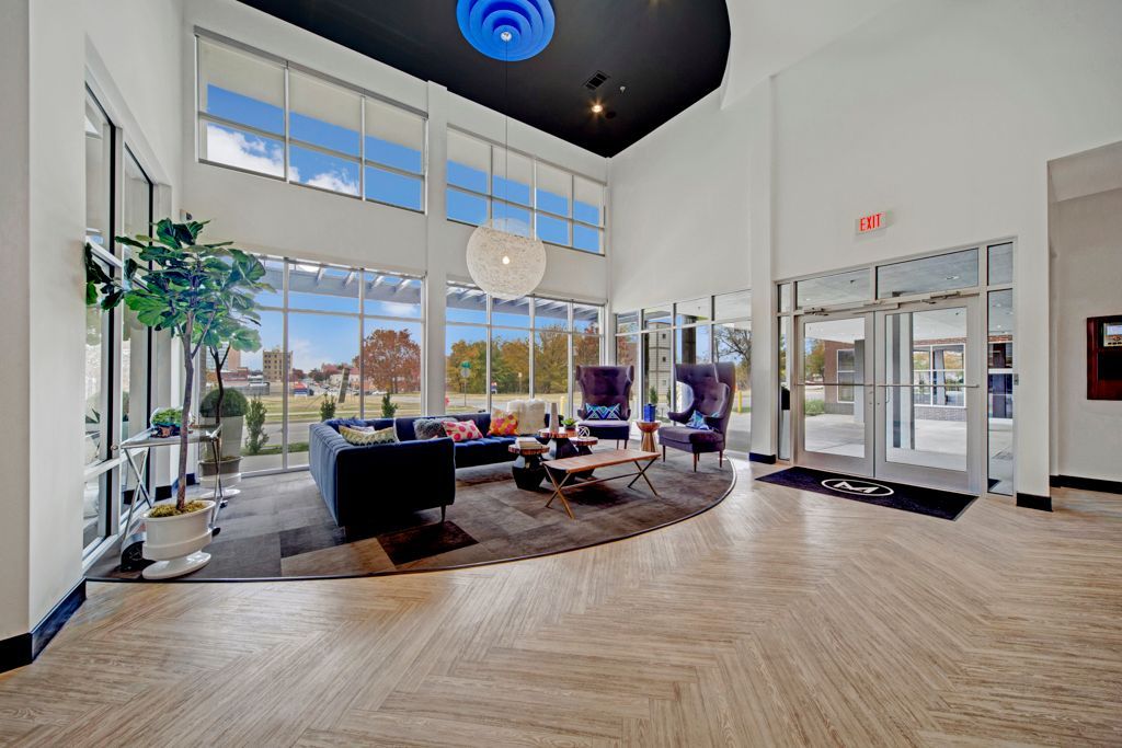 A large lobby with a lot of windows and furniture.