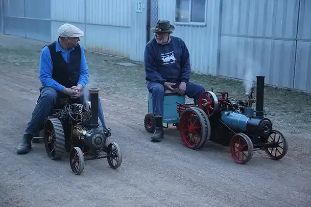 Two men having fun on miniature steam equipment at Lake Goldsmith Steam Rally