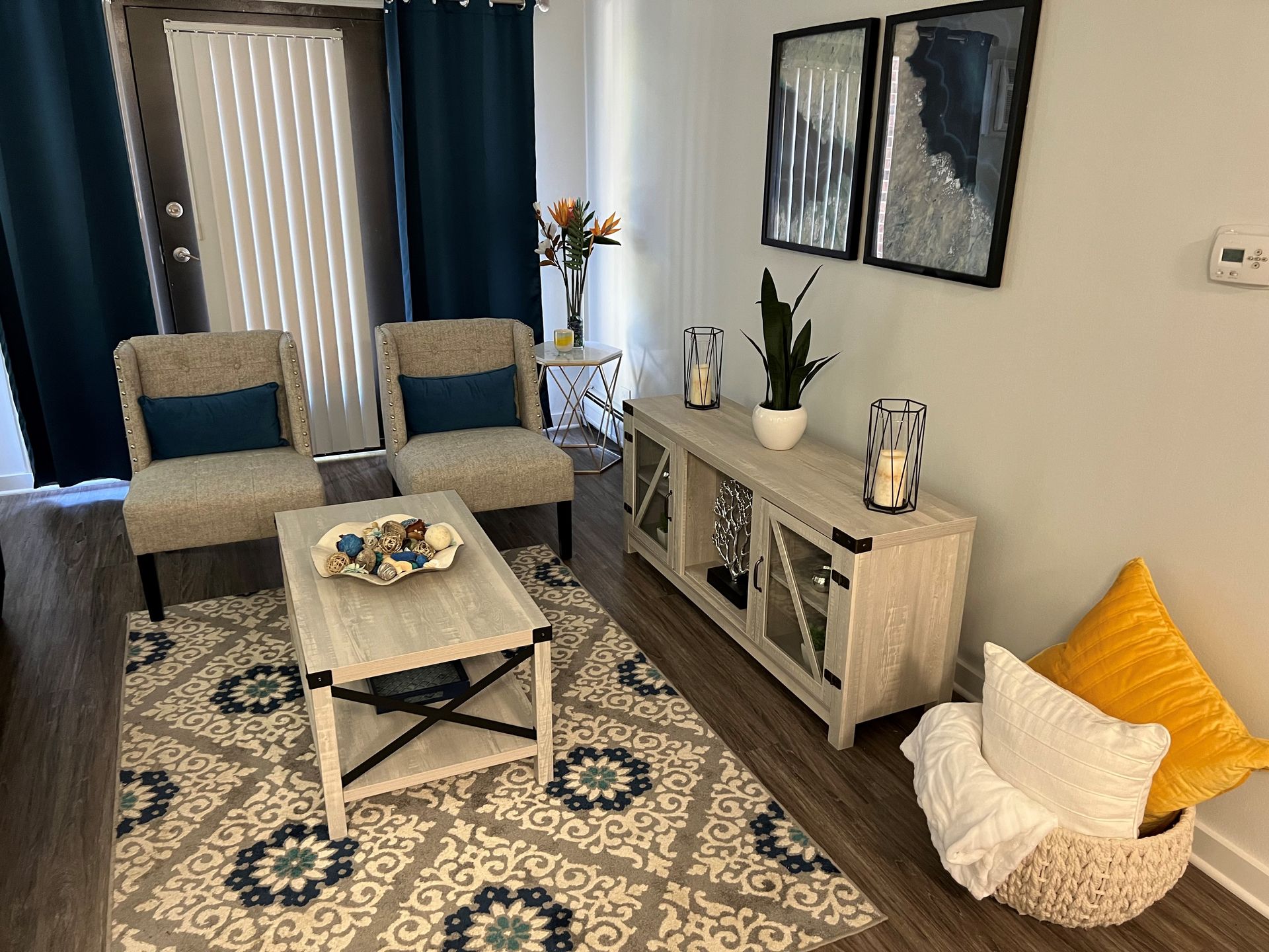 Living room with two chairs, coffee table, rug, TV stand, and decorative pillows.