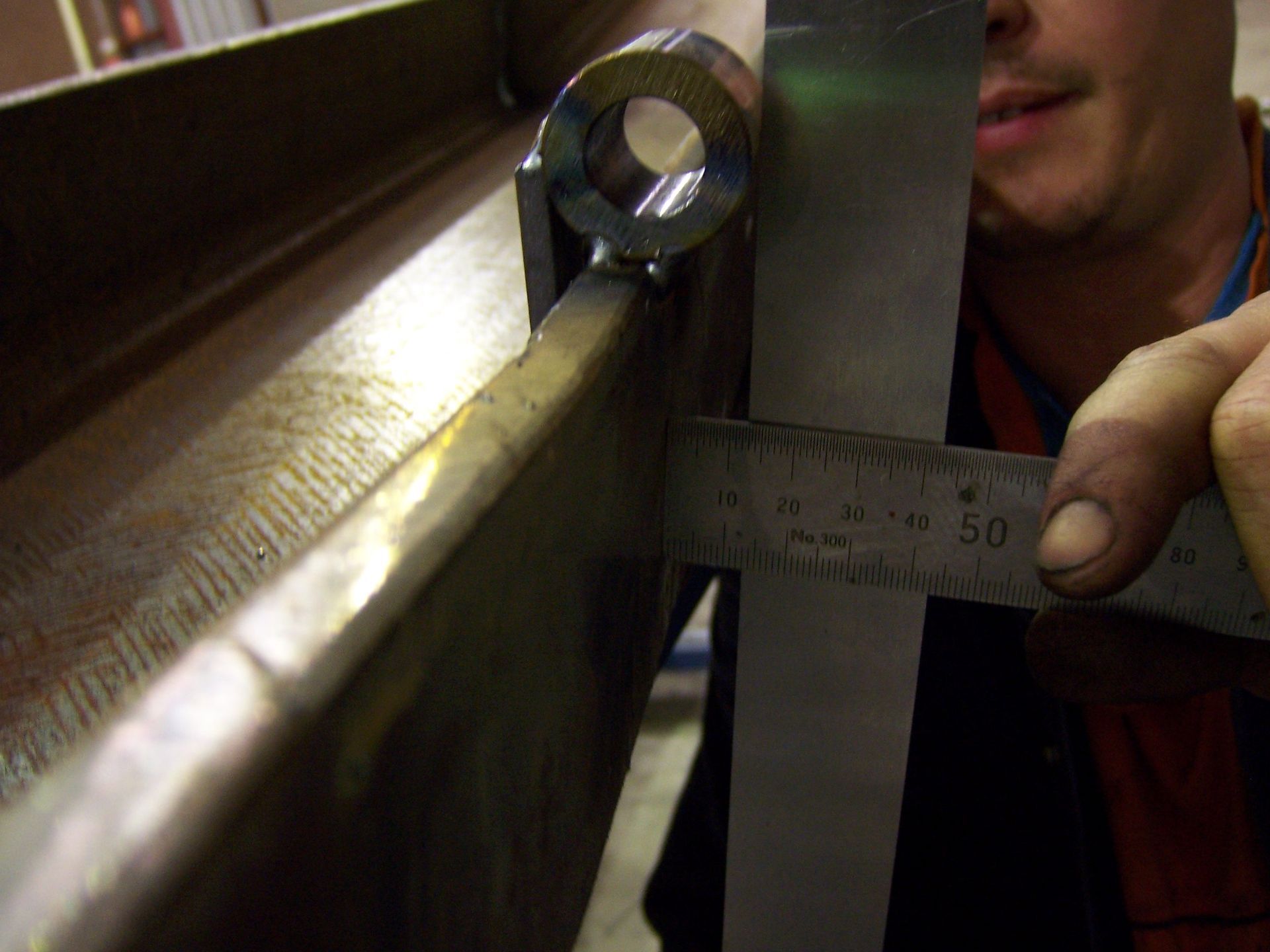 A man is measuring a piece of metal with a ruler that says 50 on it — TMF Engineering In Benalla, VIC