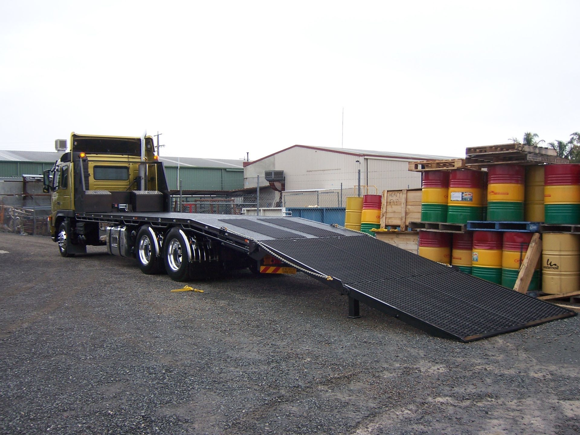 A flatbed truck is parked next to a stack of barrels — TMF Engineering In Benalla, VIC