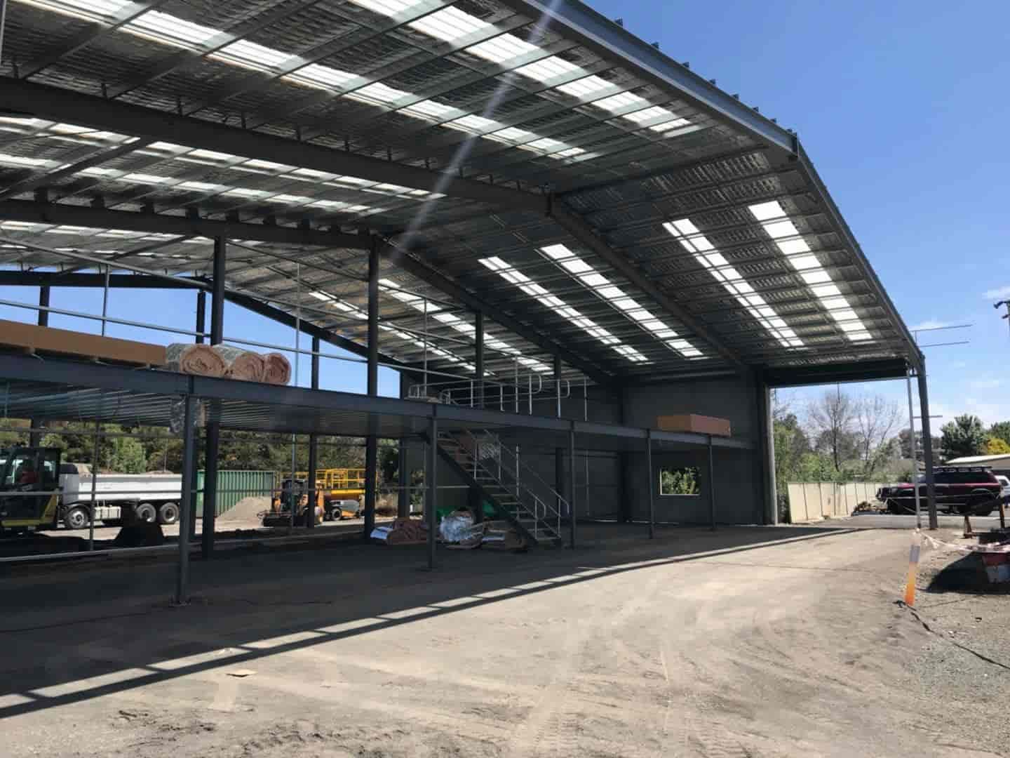 A Large Building Under Construction With A Lot Of Windows And A Truck Parked In Front Of It — TMF Engineering In Seymour, VIC