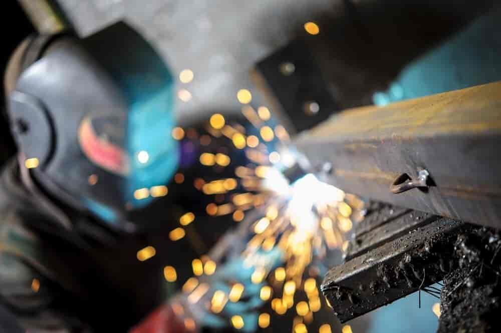 A Man Wearing A Welding Helmet Is Welding A Piece Of Metal — TMF Engineering In Seymour, VIC