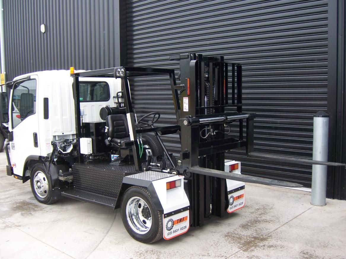 A White Truck With A Forklift Attached To The Back Is Parked In Front Of A Building — TMF Engineering In Shepparton, VIC
