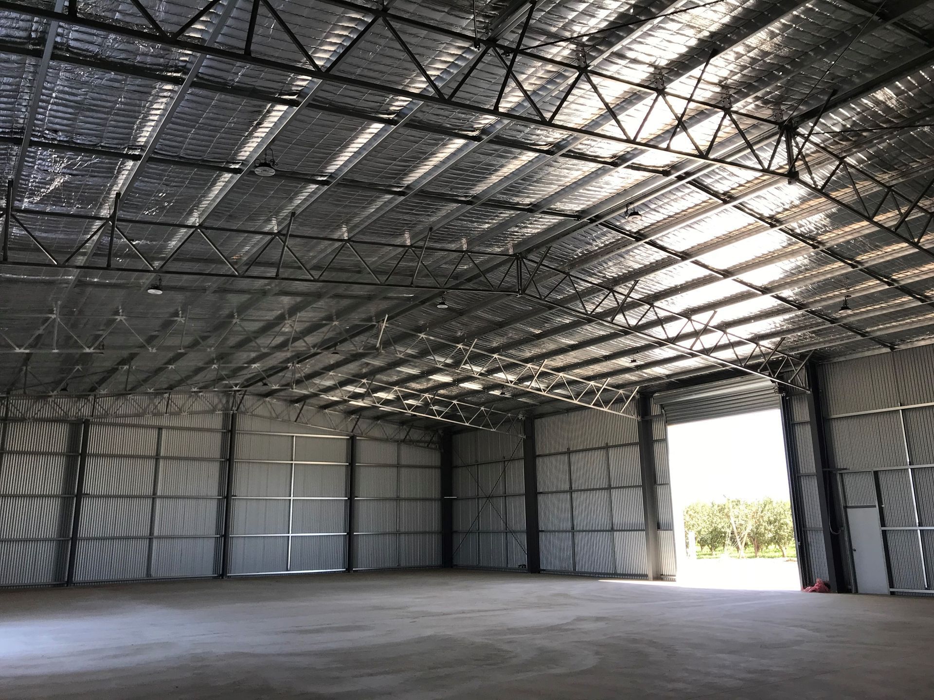The inside of a large warehouse with a large door — TMF Engineering In Benalla, VIC
