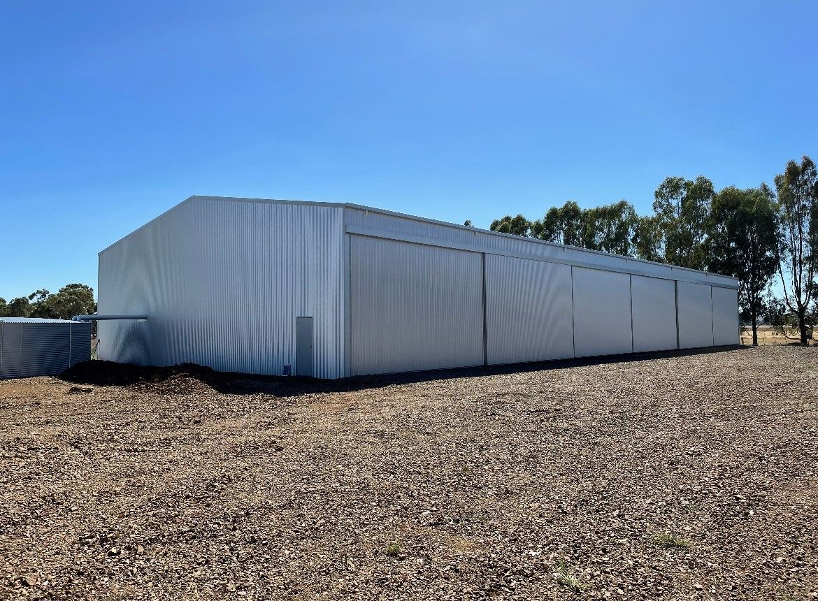 A large white building is sitting in the middle of a gravel field — TMF Engineering In Benalla, VIC