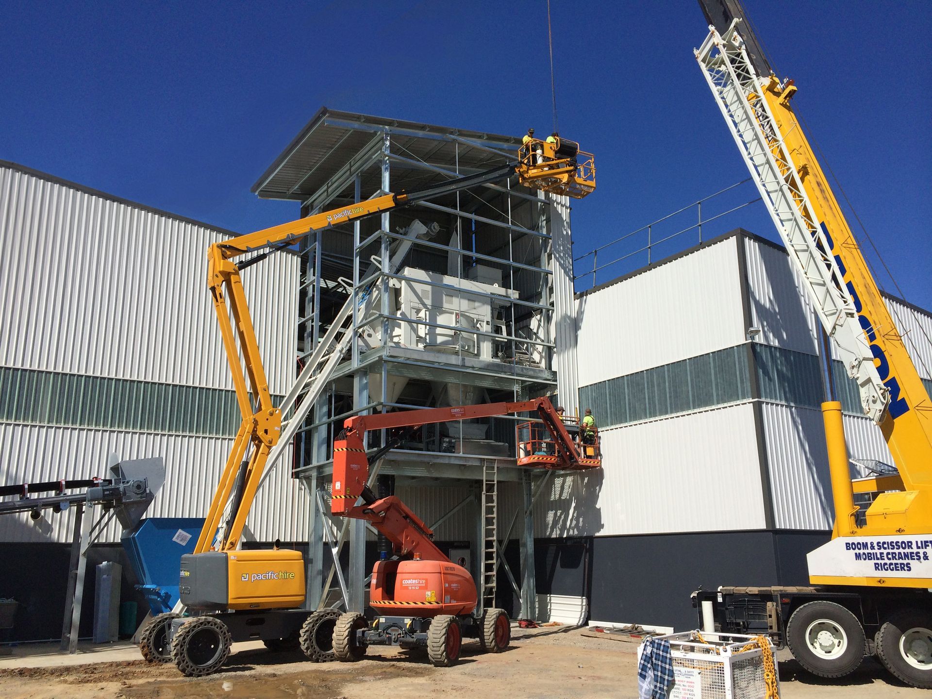 A large yellow crane is sitting in front of a building under construction — TMF Engineering In Benalla, VIC