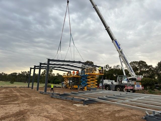 A Large Crane Is Lifting A Metal Structure In A Field — TMF Engineering In Cobram, VIC