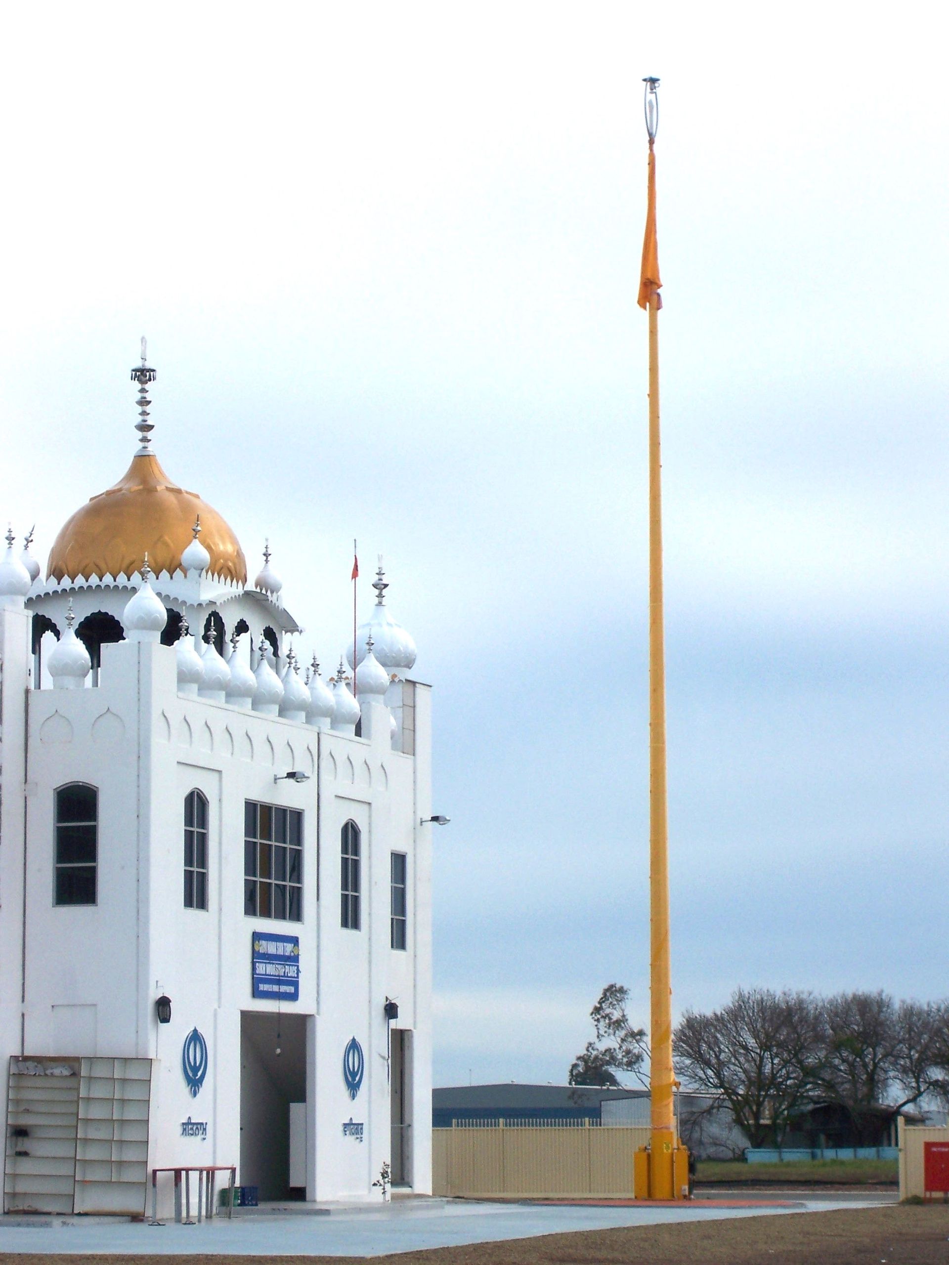 A white building with a yellow pole in front of it — TMF Engineering In Benalla, VIC
