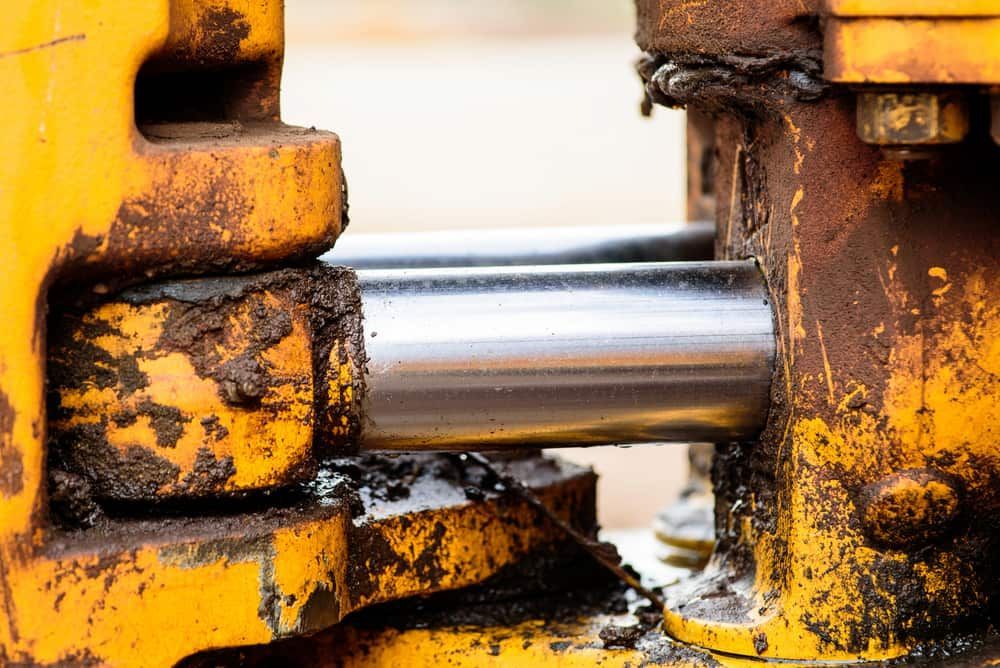 A Close Up Of A Hydraulic Cylinder On A Yellow Machine — TMF Engineering In Seymour, VIC