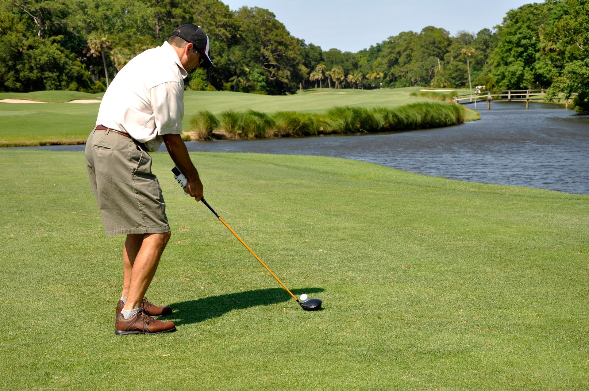 A man is swinging a golf club on a golf course