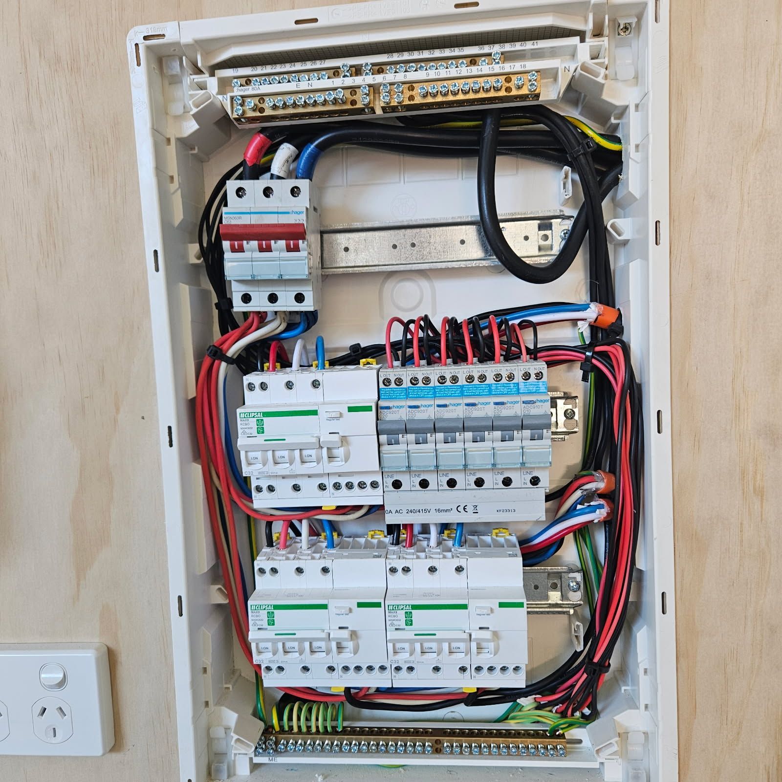 A Man Is Working On An Electrical Box With A Screwdriver — Derek Knust Electrical In Mons, QLD
