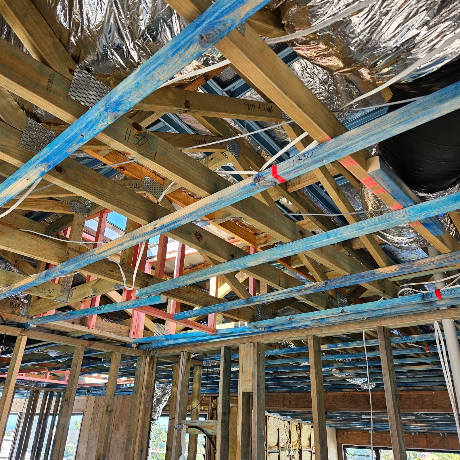 A Man Is Installing A Light Fixture On A Wall — Derek Knust Electrical In Mons, QLD
