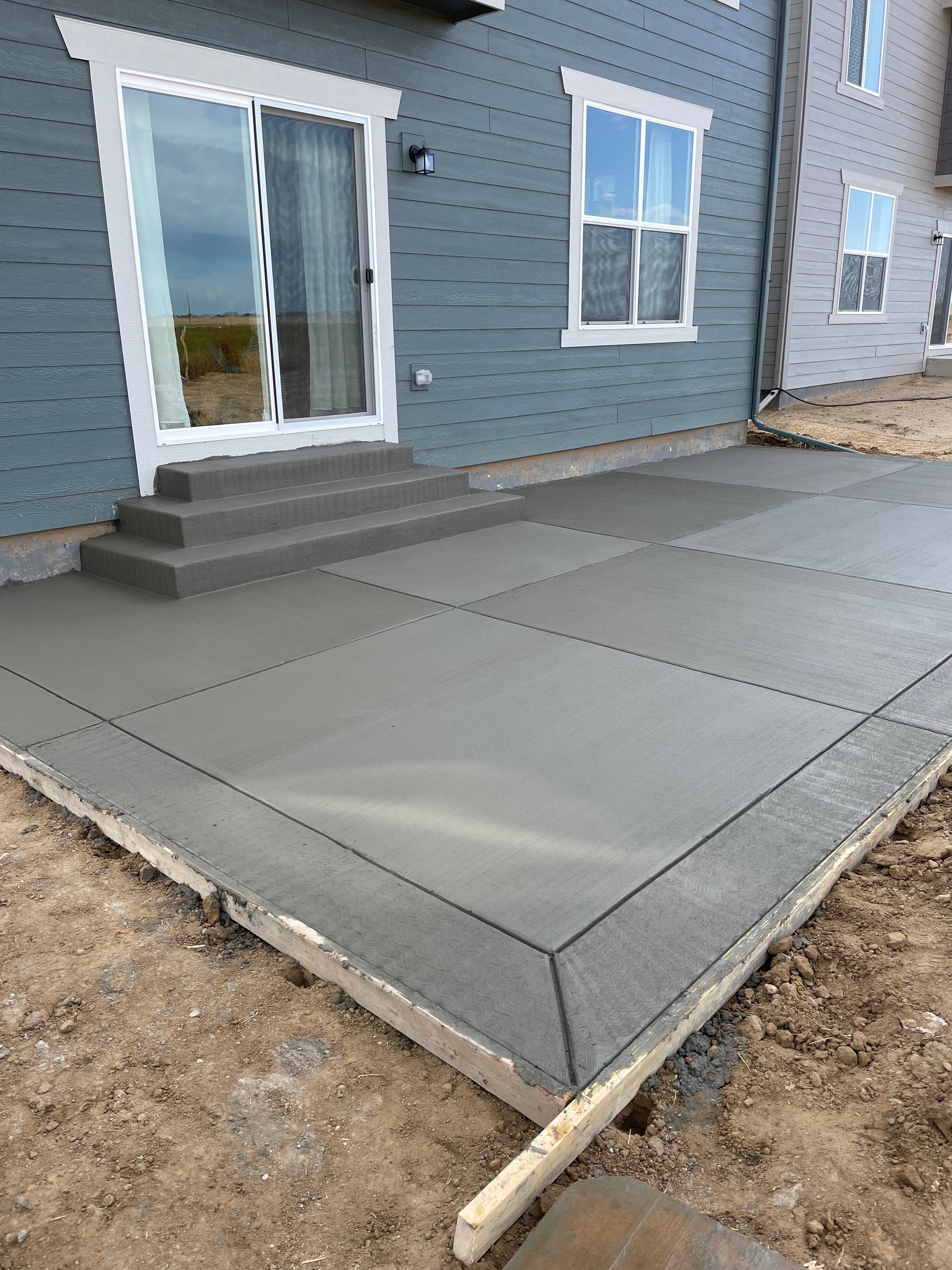 A can of soda is sitting on the ground next to a concrete floor.