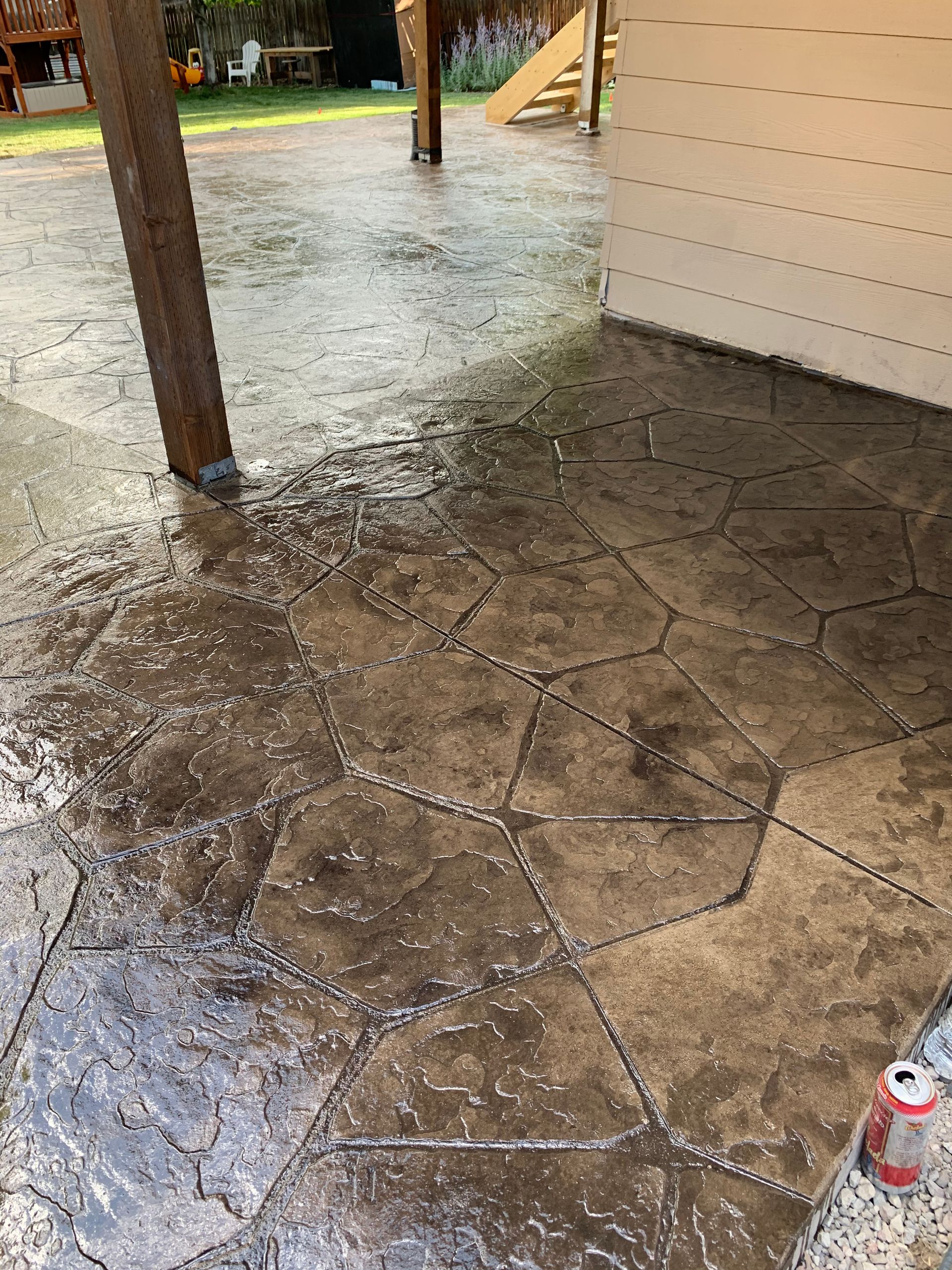 A can of soda is sitting on the ground next to a concrete floor.