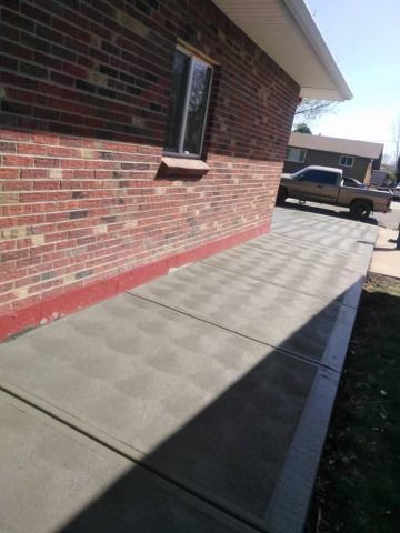 A truck is parked on the sidewalk in front of a brick building.