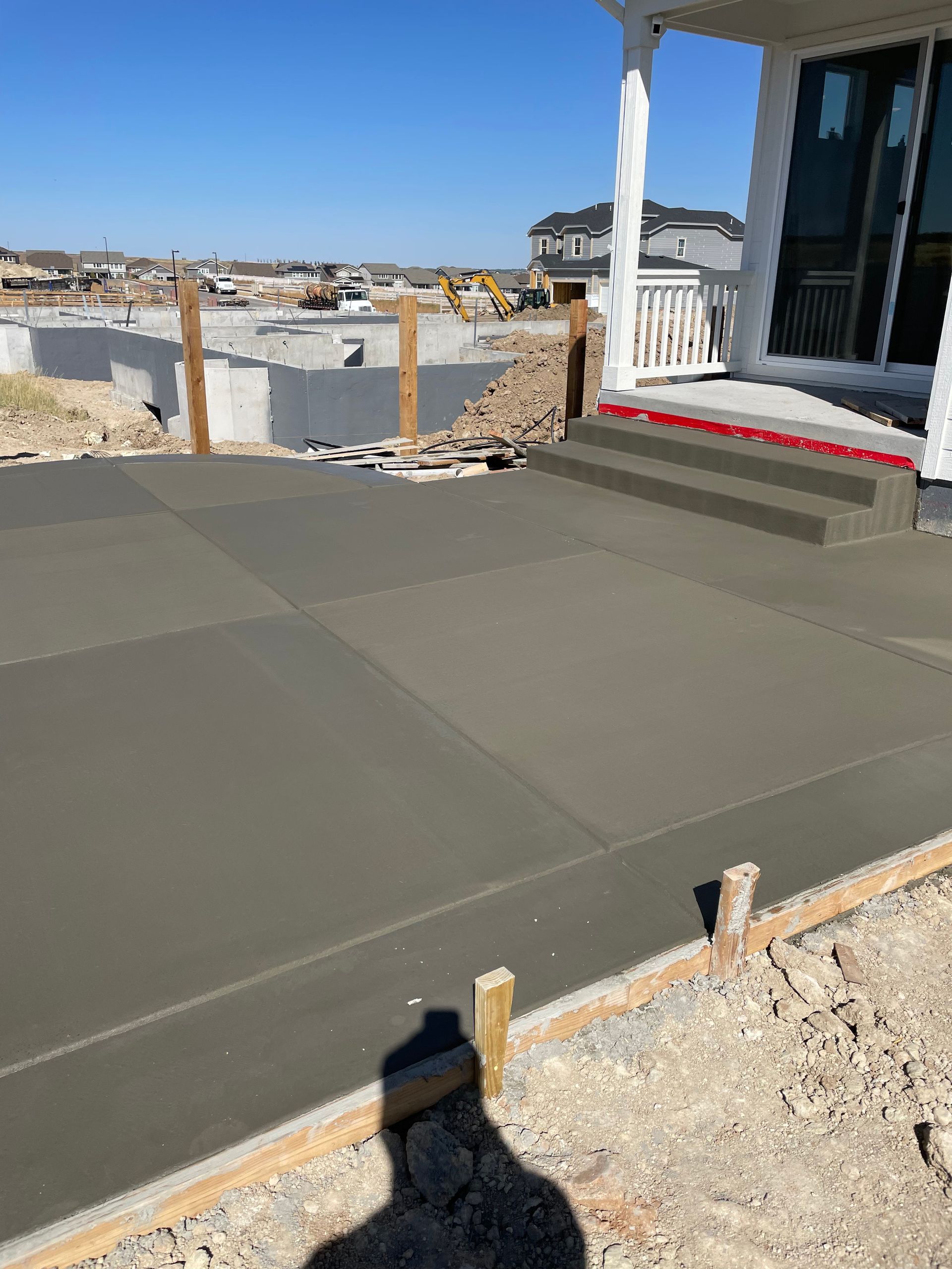 A concrete driveway is being built in front of a house.