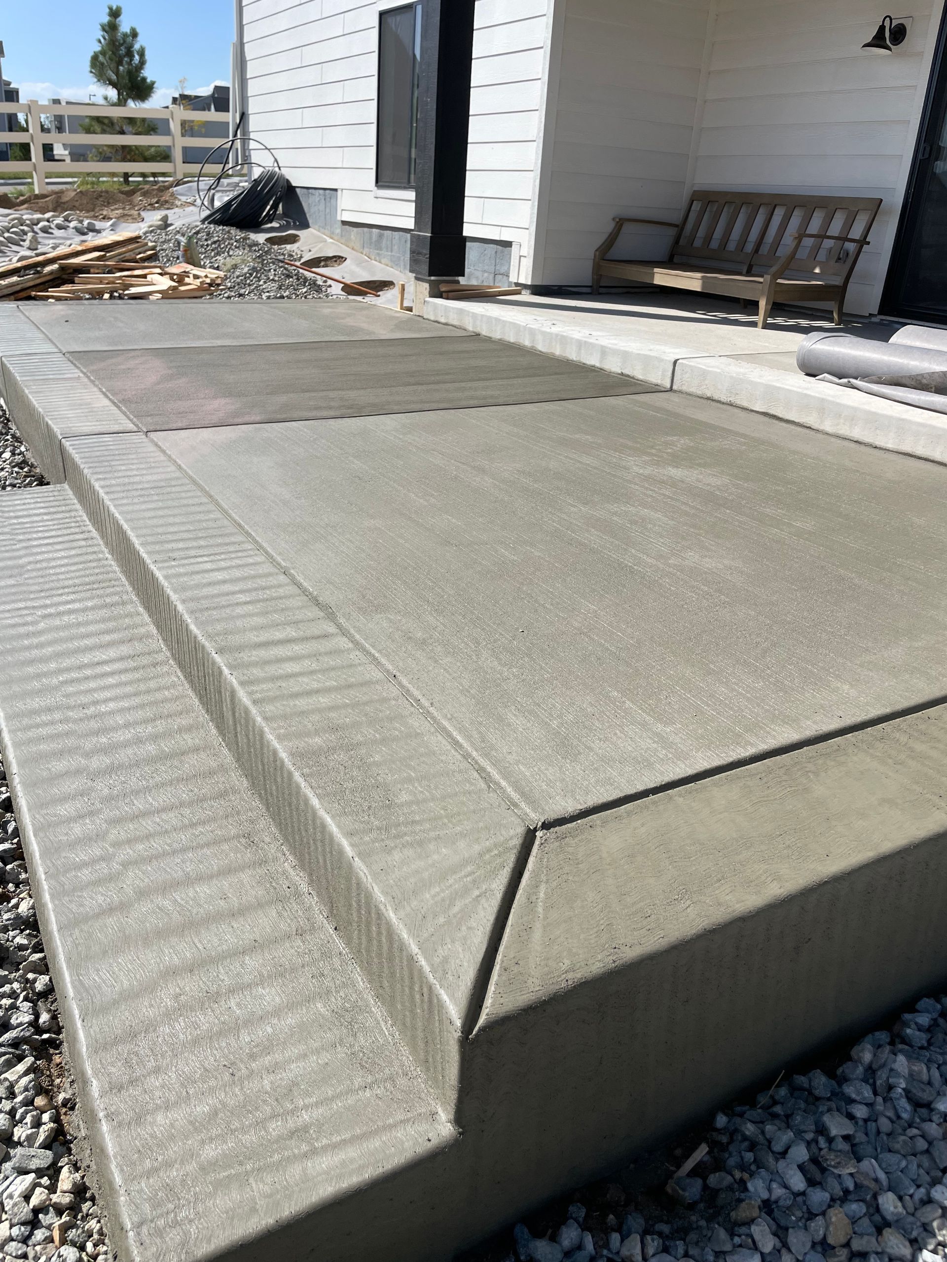 A concrete walkway is being built in front of a house.
