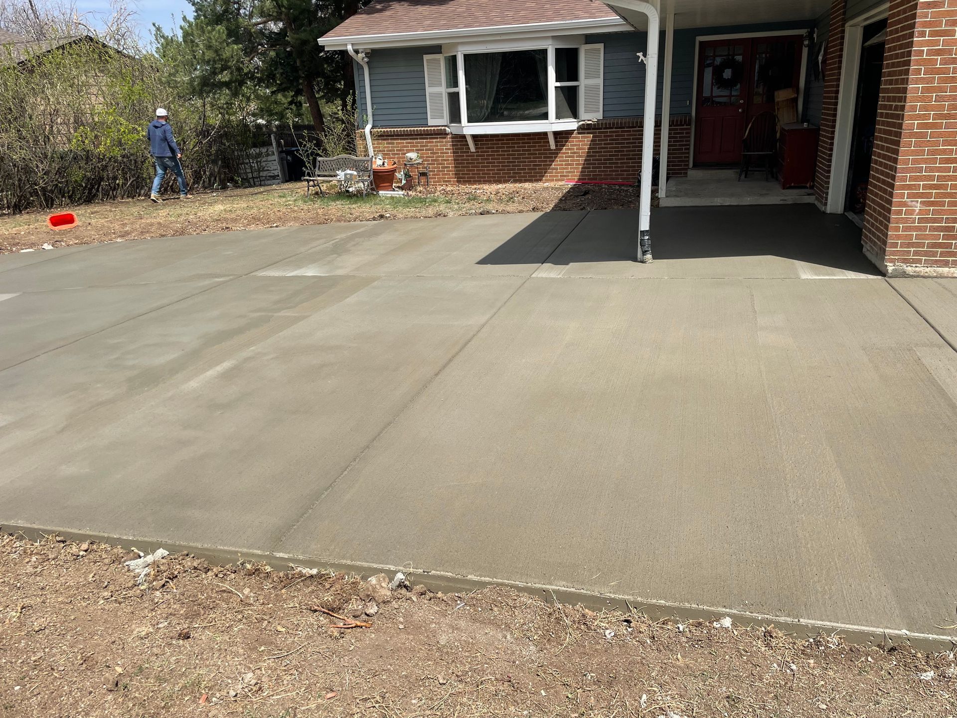 A brick house with a concrete driveway in front of it.